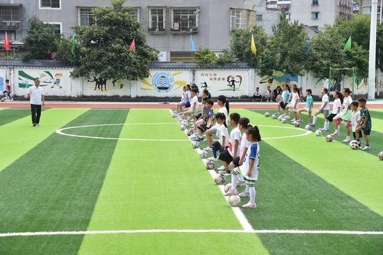  △2026年7月15日，小学生在贵州铜仁市石阡县第一小学足球场参加训练。