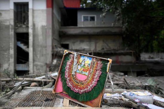 ▲当地时间2026年9月2日，尼泊尔达丁区一座损毁寺庙外的废墟上放着印度教湿婆神与帕尔瓦蒂女神的画像（图据视觉中国）