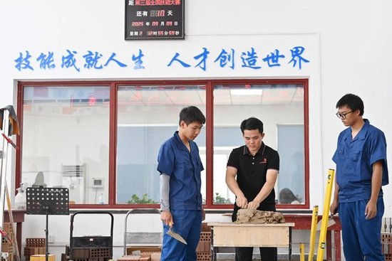 2025年9月9日，在天津铁道职业技术学院砌筑集训基地，教师伍远州指导学生实践。新华社记者 李然 摄