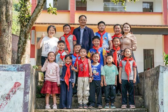 2026年3月30日，云南省文山壮族苗族自治州广南县莲城镇落松地小学教师农加贵（后排左三）、杨素芹（后排右一）、朱丽丹（后排左一）和学生在校园内合影。新华社记者 彭奕凯 摄