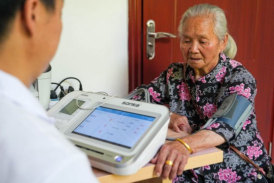 近日，曹战兰在沙洲村卫生室测量血压。新华社记者 薛宇舸 摄