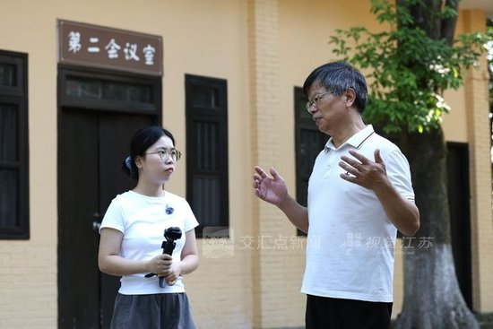 重庆市档案馆原副馆长、重庆市档案学会理事长唐润明向寻访团成员、重庆大学新闻学院学生熊娟介绍中华路历史。