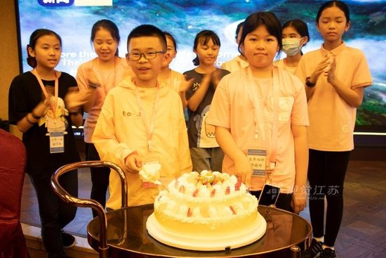 2021年“两岸青少年成渝双城研学营”在游船上举办的同龄生日晚会。（图中前排两位为分别来自重庆和台湾的小营员）