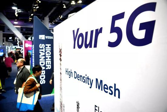  2020年1月9日，在美国拉斯维加斯举行的消费电子展上，参观者从5G技术广告旁走过。新华社记者 吴晓凌 摄