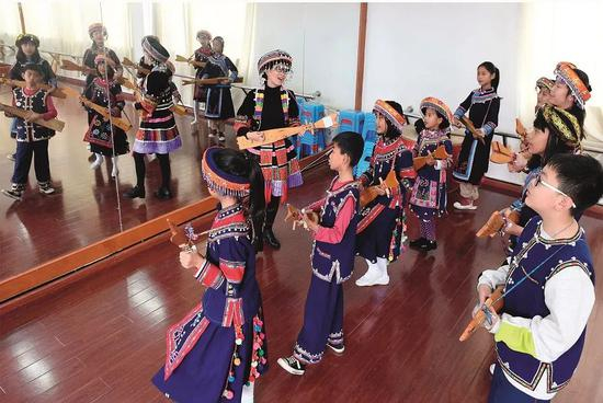  2017年1月13日，墨江县联珠镇第一小学的学生在舞蹈教室里排练哈尼族弹唱。图/新华