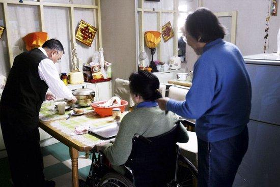 朱令的家庭生活情景之一：母亲在为其梳理头发，父亲在准备早餐（摄于2009年）