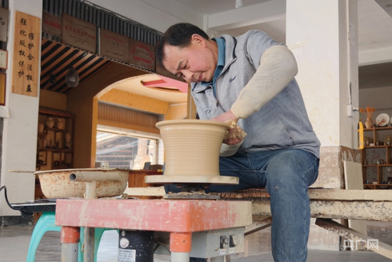  母先才在自己的陶艺馆内制作盬子（央广网记者 栾小琳 摄）