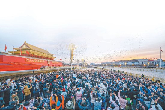  市民游客齐聚天安门广场，共同见证五星红旗冉冉升起的庄严时刻。 赵瑞摄