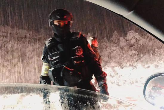 大雪中，一位提示司机路况的警察。受访者供图