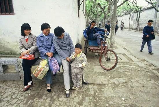 △ 1988年，扬州，路边石凳上闲聊的人与街边休息的三轮车夫。