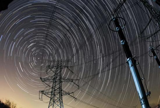 在国网淮北供电公司智能变电站拍摄的星轨中的电网设备。（本图由99张照片叠加生成）。中新社发 王璋闻 摄