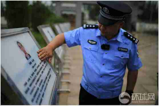 和田烈士陵园，木拉提在擦拭牺牲战友简介牌上的雨水。摄影范凌志