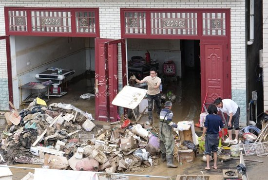5月20日，在石门县所街乡，人们在清理淤泥和垃圾。新华社记者陈振海 摄