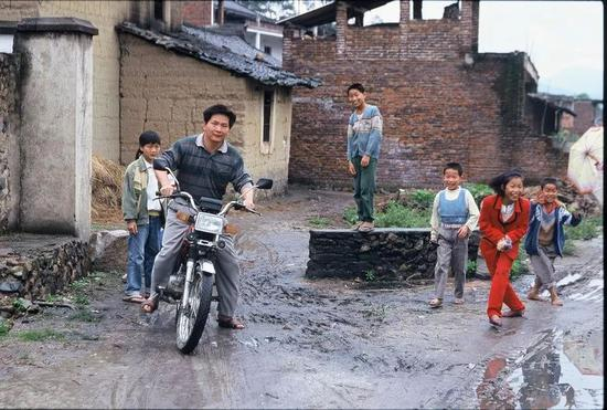 △ 1999年，福建，一男子骑着他新买的摩托车，现代化之风逐渐吹入，许多年轻人到城市找工作。