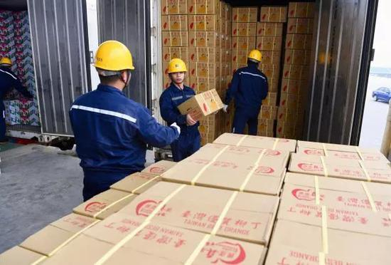  ▲资料图片：1月20日，福建平潭港区工作人员在搬运刚刚抵达的台湾水果。（新华社）