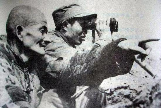 1949年渡江战役前夕，皮定均亲临江边察看地形。