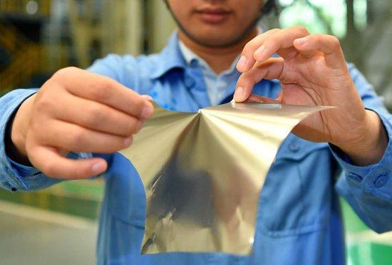 在位于山西的太钢集团，员工展示用手撕开0.02毫米厚的超薄带状不锈钢（2019年5月24日摄）。新华社记者 曹阳 摄