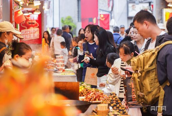国庆假期，众多游客在户部巷品尝美食。