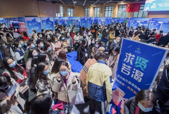 12月2日，2021届全国普通高校毕业生就业创业促进行动（湖北·武汉）对接大会在武汉举行。图为应聘者在寻找适合自己的招聘岗位。新华社记者肖艺九 摄