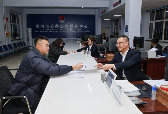 2024年12月10日，黑龙江省黑河市公共法律服务中心的工作人员在为涉外企业办理业务。新华社记者 殷刚 摄