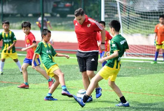 资料图：孩子们在一名外教的指导下进行训练。新华社记者 周华 摄