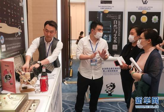 在第三届进博会消费品展区展前供需对接会上，参展商与参观者交流（2020年7月10日摄）。 新华社记者 丁汀 摄