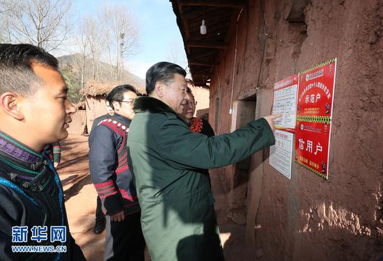 这是2018年2月11日上午，习近平在凉山彝族自治州昭觉县三岔河乡三河村详细观看扶贫联系卡。 新华社记者 谢环驰 摄