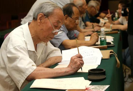 △每年,陕西师范大学都会请来数十位退休老教授和校友用毛笔为新生手书录取通知书。|图片来源:视觉中国