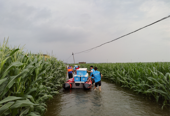 壹基金联合救灾项目-孝感市义工联合会前往被水围困的鹤壁浚县邢固村发放物资。图/壹基金