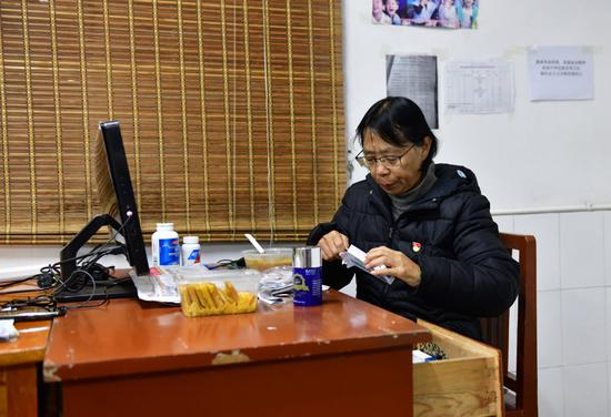 早上六点多，张桂梅在吃药（12月2日摄）。新华社发（陈欣波 摄）