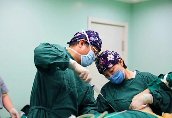  在一家整形美容诊所内，主治医生与助理正在为求美者进行抽脂手术（李伟 摄）