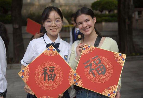  3月24日，美国华盛顿州中学生代表团成员在广州执信中学体验毛笔书法。