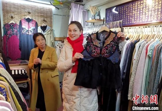 资料图：“洋媳妇”奇娜在长汀店头街选购新年衣服。张金川 摄