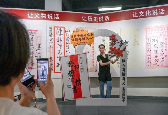 2026年5月18日，游客在广东省汕头市档案馆侨批分馆（侨批文物馆）内电影打卡点前拍照留念。新华社发（林鹏摄）