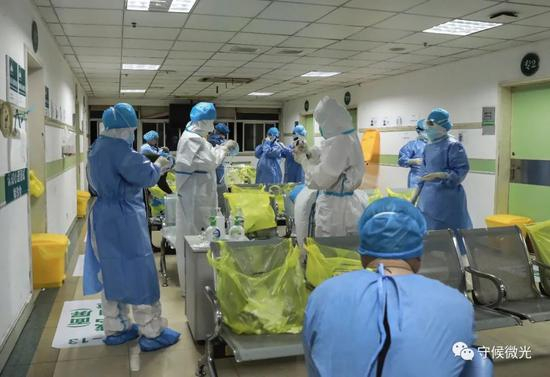 　　2月29日凌晨1点半，武汉市第一医院缓冲区内，医护人员在穿防护服。中⻘报·中青网见习记者&nbsp;鲁冲/摄