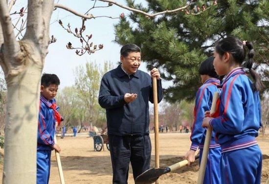 2019年4月8日,习近平总书记参加首都义务植树活动。这是习近平总书记同少先队员在一起。新华社记者 鞠鹏 摄