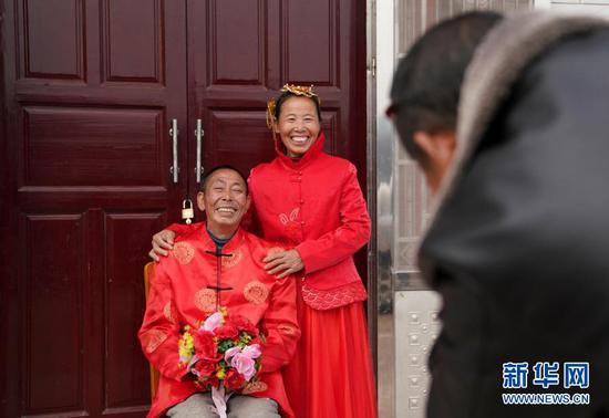 1月22日，刘仁香和丈夫赖际林穿上中式礼服拍照。江西省吉安市万安县夏造镇横江村地处一隅，曾是“十三五”贫困村。2021年农历新年来临之际，为了给脱贫摘帽的百姓带去特殊的问候，当地政府特意邀请摄影师，为20多对从未拍过婚纱照的夫妻免费上门补拍婚纱照。新华社记者 胡晨欢 摄