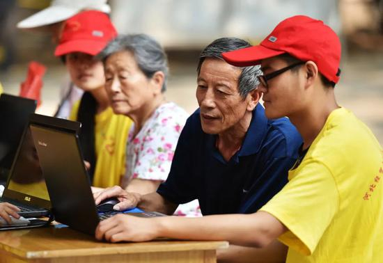  大学生党员志愿者教老年人用电脑上网。　新华社记者 王晓 摄