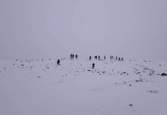 ▲救援人员在雪中搜寻失联女子