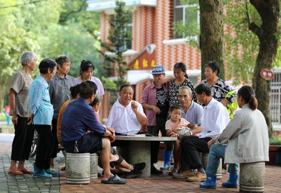 江西芦溪县宣风镇珠亭村人民调解员阳昌绍（中）为珠亭村的百姓宣讲民法典知识（2021年8月17日摄）。新华社记者 胡晨欢 摄