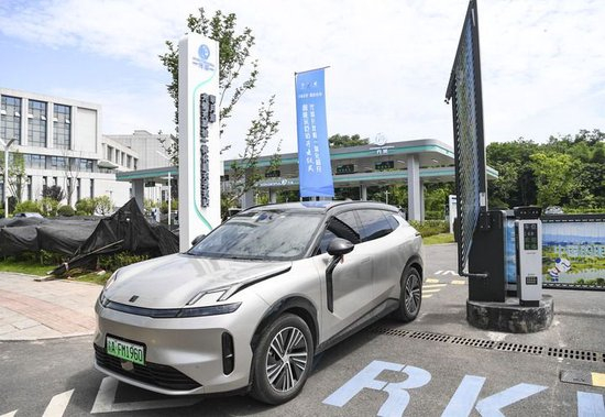  2024年6月6日，市民在重庆市两江新区明月湖超充示范站给新能源汽车充电后离开。新华社记者 王全超 摄