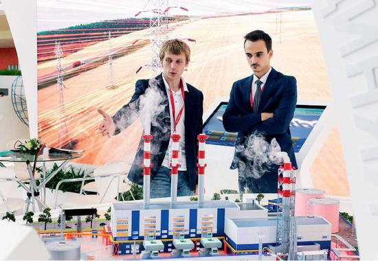  9月11日，在俄罗斯符拉迪沃斯托克第四届东方经济论坛会场，工作人员在沙盘模型前交谈。图/新华