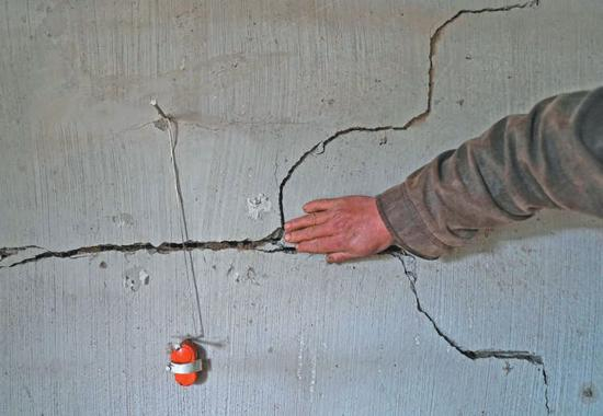 　▲中寨村民彭光华告诉记者，他家里的裂缝警报器装了半年，响了五六回。