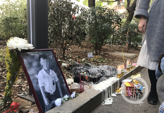  ▲事发地摆放着罗棋的照片，邻居自发悼念。摄影/上游新闻见习记者 肖鹏