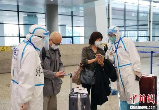 资料图：工作组人员引导入境人员有序入境。　苏宫新　摄