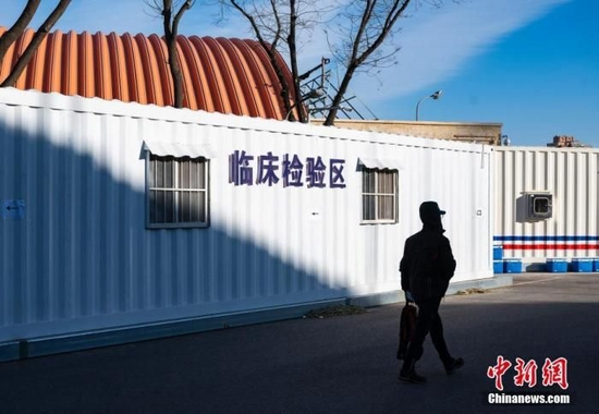 图为一位市民经过方舱发热门诊临床检验区设施。 中新社记者 侯宇 摄