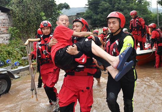 消防人员正在转移一位腿脚不便的老人