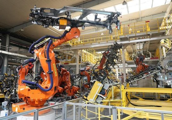 在位于浙江省临海市的吉利汽车制造基地，机械臂在焊装车间工作。新华社记者 翁忻旸 摄