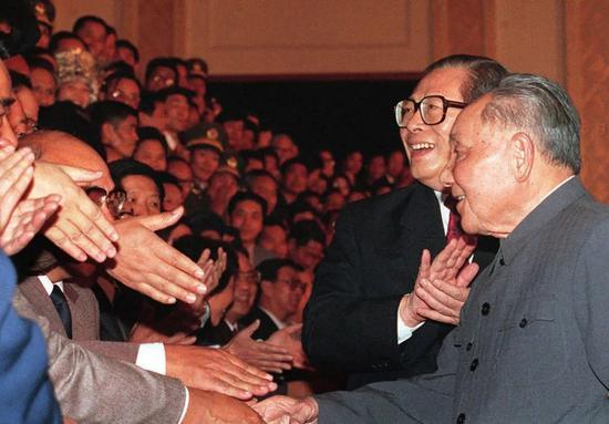 　　1992年10月19日，在北京人民大会堂，邓小平在江泽民的陪同下，绕场一周，和代表们见面。1992年10月12日至18日，中国共产党举行第十四次全国代表大会。大会明确提出了中国经济体制改革的目标是建立社会主义市场经济体制。图/新华
