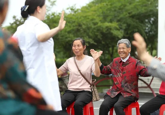  5月28日，湖北省荆门市东宝区石桥驿镇河垱村，当地村民跟着家庭医生学习养生“健康操”。赵平摄（中经视觉）